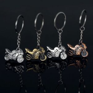 Mini motorcycle keychains in metallic finishes on black background, showcasing detailed craftsmanship.